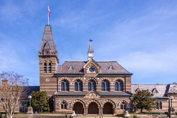 Chapel Hall is silhouetted against the blue sky, with Tower Clock and windows visible. 