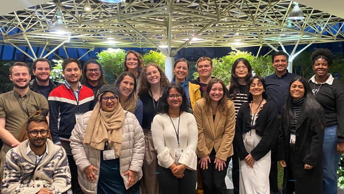 A group photo of staff and attendees at the ASSETS Conference. In the back, second from the left, is Gallaudet Associate Professor Abraham Glasser. In the back, second from the right, is Gallaudet Professor Raja Kushalnagar. They are surrounded by 16 other smiling people.