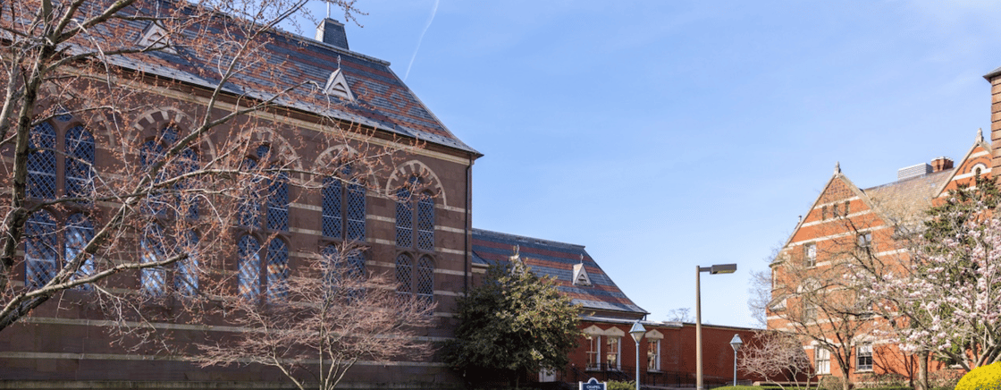 A photo of Chapel Hall and College Hall with trees on both sides.
